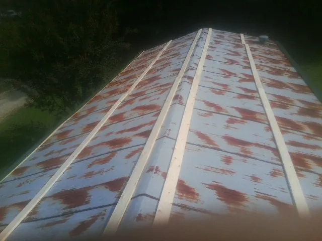 Rusted metal roof panels with new wood purlins before replacement — Storm Damage Roof Repair in Eastport by Roofing Brothers